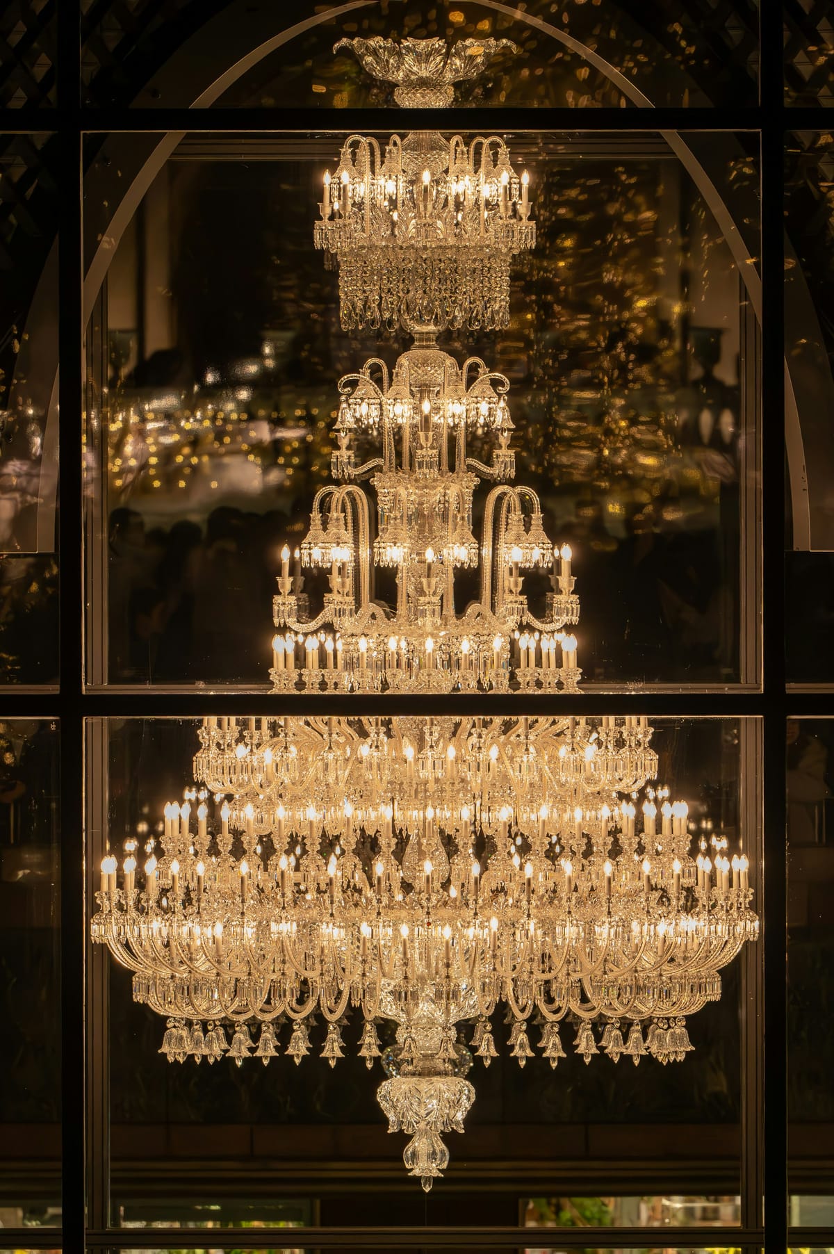 A crystal chandelier glowing in a dark hall